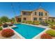 Relaxing backyard oasis featuring a sparkling pool, manicured landscaping, and comfortable patio seating at 18663 W Vogel Ave, Goodyear, AZ 85338