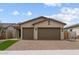 Charming single-story home featuring a brick driveway, a three-car garage, and a well-maintained front yard at 19321 W Luke Ave, Litchfield Park, AZ 85340