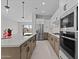 Modern kitchen featuring stainless steel appliances, two-toned cabinetry, quartz countertops, and a spacious island with a sink at 19321 W Luke Ave, Litchfield Park, AZ 85340