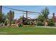 Community playground with modern play structure, sun shades, and green grass at 19321 W Luke Ave, Litchfield Park, AZ 85340