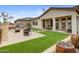 Serene backyard featuring a covered patio, an outdoor dining area, and lush artificial turf at 19426 W San Juan Ave, Litchfield Park, AZ 85340