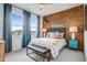 Comfortable bedroom with a brick accent wall and abundant natural light at 19426 W San Juan Ave, Litchfield Park, AZ 85340