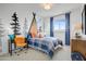 Charming bedroom with plaid bedding, playful tree murals, and a sunlit window with blue curtains at 19426 W San Juan Ave, Litchfield Park, AZ 85340