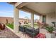 Inviting covered patio featuring comfortable seating, an outdoor dining area, and a landscaped backyard at 19426 W San Juan Ave, Litchfield Park, AZ 85340