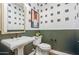 Stylish powder room with a pedestal sink, a contemporary mirror, and a decorative wallpaper at 19426 W San Juan Ave, Litchfield Park, AZ 85340