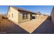 Wide angle view of the home's rear facade with a covered patio and a expansive dirt backyard fenced with block wall at 20073 S 231St Pl, Queen Creek, AZ 85142