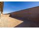 Expansive dirt backyard, enclosed by a tall block wall, offering a private and customizable outdoor space at 20073 S 231St Pl, Queen Creek, AZ 85142