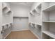 Well-organized walk-in closet with shelving units, hanging rods and neutral carpet at 20073 S 231St Pl, Queen Creek, AZ 85142
