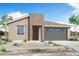 Charming single-story home with desert landscaping and a gray garage door at 24179 W Agora Ln, Buckeye, AZ 85326
