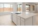 Kitchen island with sink and seating area, complemented by ample natural light at 24791 N 169Th Dr, Surprise, AZ 85387