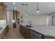 Modern kitchen island with granite countertops, sink, stainless steel appliances, and tile flooring at 32541 N 135Th Dr, Peoria, AZ 85383