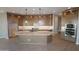 Open kitchen features a large island, stylish lighting, wood cabinets, tile flooring, and stainless steel appliances at 32541 N 135Th Dr, Peoria, AZ 85383