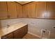 Functional laundry room with sink, countertop space, and plenty of storage cabinets at 32541 N 135Th Dr, Peoria, AZ 85383