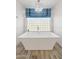 A modern bathtub is lit by a chandelier and large window at 3665 S Jojoba Way, Chandler, AZ 85248