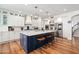 Kitchen boasts white cabinets, stainless steel appliances, and a large island with seating and pendant lights at 3665 S Jojoba Way, Chandler, AZ 85248