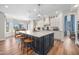 A large kitchen island with seating, white cabinets, hardwood floors, and stainless steel appliances at 3665 S Jojoba Way, Chandler, AZ 85248