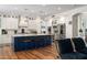 A spacious kitchen features an island with seating, white cabinets, stainless steel appliances, and hardwood floors at 3665 S Jojoba Way, Chandler, AZ 85248