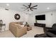 Cozy living room features a comfortable sectional sofa, entertainment center, and neutral carpet at 3665 S Jojoba Way, Chandler, AZ 85248