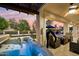 Covered patio featuring a hot tub, ceiling fan and comfortable seating area overlooking the manicured golf course at 3665 S Jojoba Way, Chandler, AZ 85248