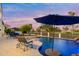 Backyard pool featuring a rock waterfall, in-pool seating and lounge chairs with a view of the golf course at 3665 S Jojoba Way, Chandler, AZ 85248