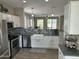Modern kitchen with stainless steel appliances, white cabinetry, and view to living room at 3677 E Park Ave, Gilbert, AZ 85234