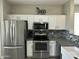 Bright kitchen featuring stainless steel appliances, white cabinets, and stylish backsplash at 3677 E Park Ave, Gilbert, AZ 85234