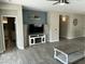 Open-concept living room with accent wall, tile floors, neutral paint, and a ceiling fan at 3677 E Park Ave, Gilbert, AZ 85234