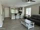Open-concept living room with tile floors, neutral paint, and a view into the kitchen and breakfast bar at 3677 E Park Ave, Gilbert, AZ 85234