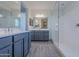Bathroom with double sinks, large mirrors, modern vanities, and a glass shower at 39980 W Bunker Dr, Maricopa, AZ 85138