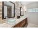 Stylish bathroom with double sinks, stone accent wall, and decorative mirrors at 401 E Braeburn Dr, Phoenix, AZ 85022