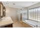 Bright bathroom with dual sinks, glass block shower, and soaking tub under a large window at 401 E Braeburn Dr, Phoenix, AZ 85022