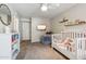 Neutral-toned bedroom featuring a ceiling fan, carpeted floors, and a full-sized crib at 401 E Braeburn Dr, Phoenix, AZ 85022