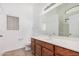 Bright bathroom with a wood vanity, white countertop, large mirror, and walk-in shower at 40329 W Thornberry Ln, Maricopa, AZ 85138