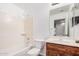 Traditional bathroom with combination tub and shower plus a vanity and framed mirror at 40329 W Thornberry Ln, Maricopa, AZ 85138