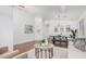 Open-concept living space with dining area, stylish decor, light-colored walls, and wood-style floors at 40329 W Thornberry Ln, Maricopa, AZ 85138