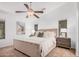 Comfortable main bedroom with neutral tones, a ceiling fan, carpeted floors, and two bedside tables at 40329 W Thornberry Ln, Maricopa, AZ 85138