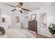 Cozy main bedroom with neutral tones, a wooden dresser, carpeted floors, and an ensuite bathroom at 40329 W Thornberry Ln, Maricopa, AZ 85138