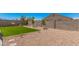 Landscaped backyard featuring green lawn, decorative rock, block fence and young trees at 4114 S 106Th Dr, Tolleson, AZ 85353