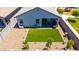 Backyard aerial view of home showcasing lawn, desert landscaping, and covered patio at 4114 S 106Th Dr, Tolleson, AZ 85353