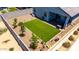 Aerial view of the backyard featuring green lawn, decorative rock, and young trees at 4114 S 106Th Dr, Tolleson, AZ 85353
