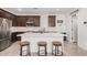 Charming kitchen with stainless steel appliances, white countertops, dark brown cabinetry, and barstool seating at 4114 S 106Th Dr, Tolleson, AZ 85353