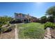 The spacious back yard features manicured green grass, mature trees, and a covered patio at 4306 E Raven Rd, Phoenix, AZ 85044