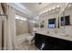 Bright bathroom features a shower-tub, updated vanity with black cabinets and neutral tiling at 4306 E Raven Rd, Phoenix, AZ 85044