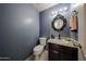 Charming half bathroom features a unique ornate mirror, updated vanity, and well-maintained fixtures at 4306 E Raven Rd, Phoenix, AZ 85044