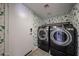 Convenient laundry room equipped with modern washer and dryer units, accented by patterned wallpaper at 4306 E Raven Rd, Phoenix, AZ 85044