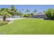 Expansive backyard featuring lush artificial grass, a sparkling pool, and mature palm trees at 625 E Silver Creek Rd, Gilbert, AZ 85296