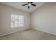 This bedroom features a ceiling fan and a large window, creating a bright and airy atmosphere at 625 E Silver Creek Rd, Gilbert, AZ 85296