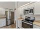 Bright kitchen features stainless steel appliances, white cabinets, and complementary countertops at 625 E Silver Creek Rd, Gilbert, AZ 85296