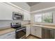 Bright kitchen features white cabinets, stainless steel appliances, and a window over the sink at 625 E Silver Creek Rd, Gilbert, AZ 85296