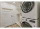 Laundry room featuring front loading washer and dryer, white cabinets and a door at 625 E Silver Creek Rd, Gilbert, AZ 85296